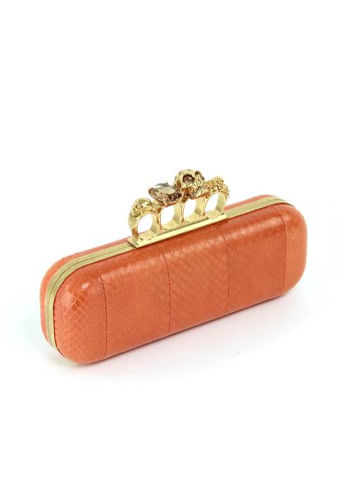 Orange leather clutch bag with gold jewellery
