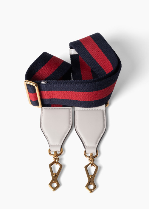 Bandoulière en toile Web avec des détails en cuir blanc et une quincaillerie dorée.