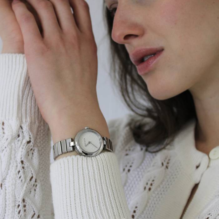 Uhr mit silbernem Rahmen und weißem Zifferblatt Gucci