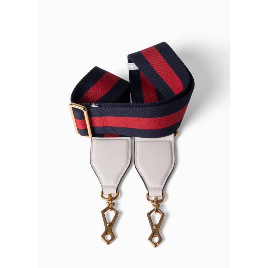 Bandoulière en toile Web avec des détails en cuir blanc et une quincaillerie dorée.